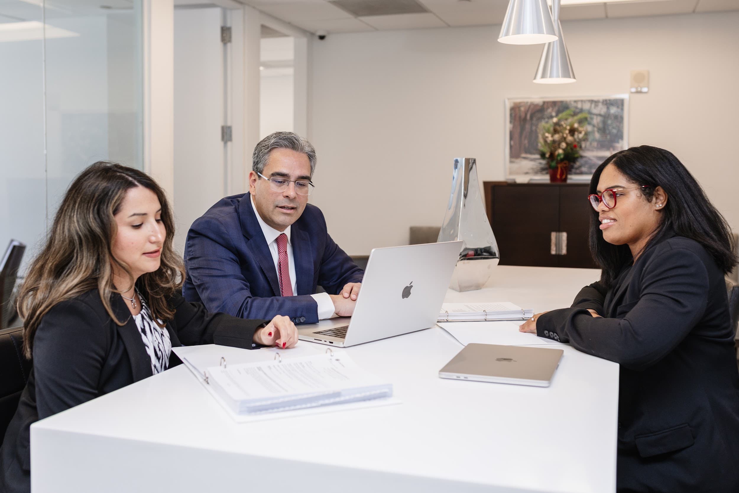 Fridman Fels & Soto attorneys reviewing documents together around a conference table
